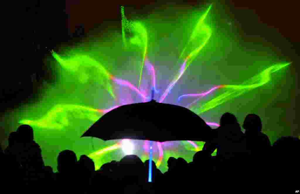 People watch a fountain light show in Warsaw, Poland, May 3, 2013. 