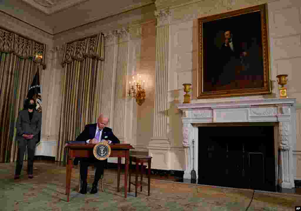조 바이든 미국 대통령이 백악관에서 카멀라 해리스 부통령이 지켜보는 가운데 인종평등 행정명령에 서명하고 있다. 