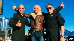 Richard Branson center celebrates with pilots Rick “CJ” Sturckow, left, and Mark “Forger” Stucky, right, after Virgin Galactic’s tourism spaceship climbed more than 50 miles high above California’s Mojave Desert on Thursday, Dec. 13, 2018. (AP Photo/John