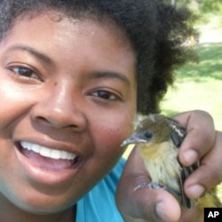 Lee blogs about science you can see in your neighborhood park or backyard. Here, she holds a young goldfinch.