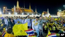 Raja Maha Vajiralongkorn (kiri tengah) dan Ratu Suthida, melambaikan tangan ke kanan tengah kepada para pendukung di Bangkok, Thailand, 1 November 2020.