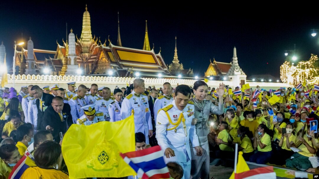 Raja Thailand Maha Vajiralongkorn (tengah kiri) dan Ratu Suthida (tengah kanan), melambaikan tangan ke arah para demonstran di Bangkok, Thailand, Minggu, 1 November 2020.