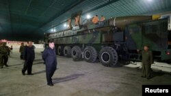 지난 2017년 7월 김정은 북한 국무위원장이 화성-14 장거리탄도미사일과 이동차량을 둘러보는 사진을, 북한 매체가 공개했다. (자료사진)
