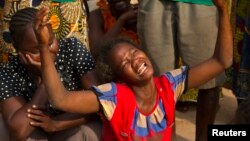 A woman reacts near the dead body of her sister who was killed during one of the latest incidents of sectarian violence in the 5th Arrondissement of the capital Bangui February 9, 2014. REUTERS/Siegfried Modola (CENTRAL AFRICAN REPUBLIC - Tags: CIVIL UNRE