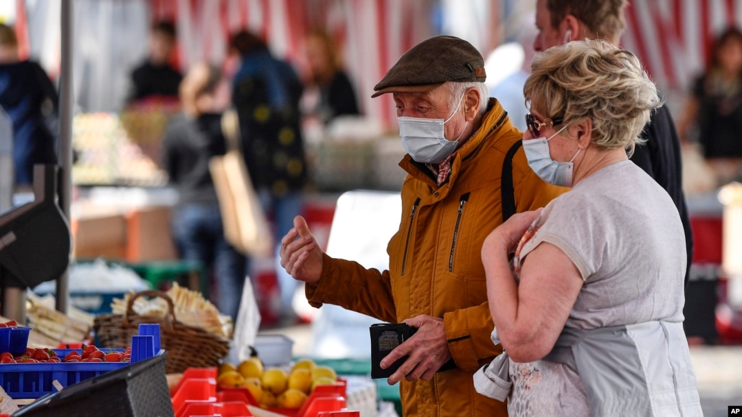Orang lanjut usia menggunakan masker untuk melindungi dari virus corona tengah berbelanja di pasar di Aachen, Jerman, Kamis, 9 April 2020. (Foto: AP)