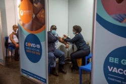 FILE - A policeman receives his COVID-19 vaccine in Soweto, South Africa, July 5 2021.