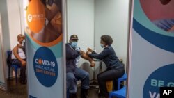 FILE - A policeman receives his COVID-19 vaccine in Soweto, South Africa, July 5 2021.
