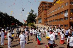 FILE - Indian Navy's Chetak helicopter shower flower petals in the premises of a hospital as part of an event to show gratitude towards the frontline warriors fighting the COVID-19 outbreak, in Visakhapatnam, India, May 3, 2020.