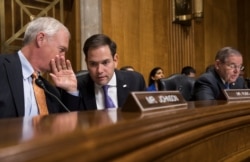 Sen. Marco Rubio, R-Fla., center, confers with Sen. Ron Johnson, R-Wisc., as Sen. Bob Menendez, D-N.J., far right, speaks on Capitol Hill in Washington, Jan. 9, 2018.