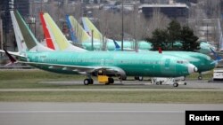 FILE - Boeing 737 Max aircraft, including a 737 Max 8 aircraft bearing the logo of China Southern Airlines (3rd left), are parked at a Boeing production facility in Renton, Washington, March 11, 2019.