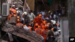 Rescuers work at the site of a building that collapsed in Mumbai, India, Tuesday, July 16, 2019. 