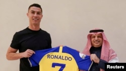 Portuguese soccer player Cristiano Ronaldo holds a shirt of the Saudi club Al-Nassr after signing the contract