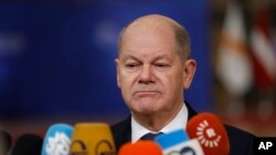 FILE - Germany's Chancellor Olaf Scholz speaks with the media as he arrives for an EU summit at the European Council building in Brussels, Dec. 19, 2024.