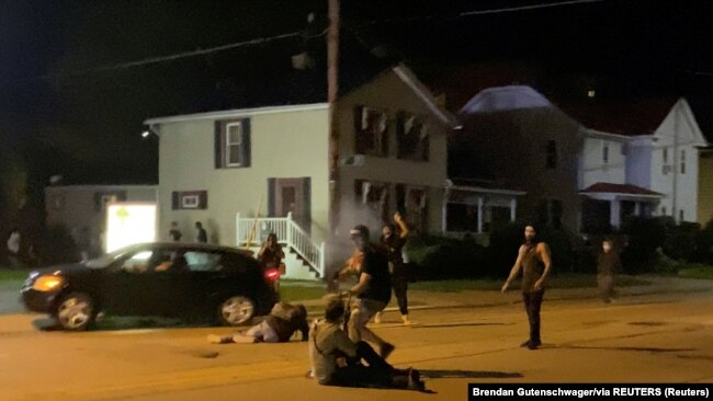 USA, Visconsin, Kenosha, A man is being shot in his arm during a protest following the police shooting of Jacob Blake