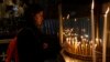 Christian worshiper lights candles at the Church of the Nativity, built atop the site where Christians believe Jesus Christ was born, on Christmas Eve, in the West Bank City of Bethlehem, Dec. 24, 2017. 