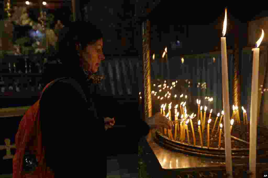 فلسطین کے شہر بیت الحم میں واقع تاریخی &#39;چرچ آف نیٹیویٹی&#39; میں کرسمس کی شب ہونے والی خصوصی دعائیہ تقریب میں شریک خاتون موم بتیاں جلا رہی ہیں۔ یہ چرچ اس مقام پر واقع ہے جہاں روایات کے مطابق حضرت عیسیٰ کا جنم ہوا تھا۔ &nbsp;