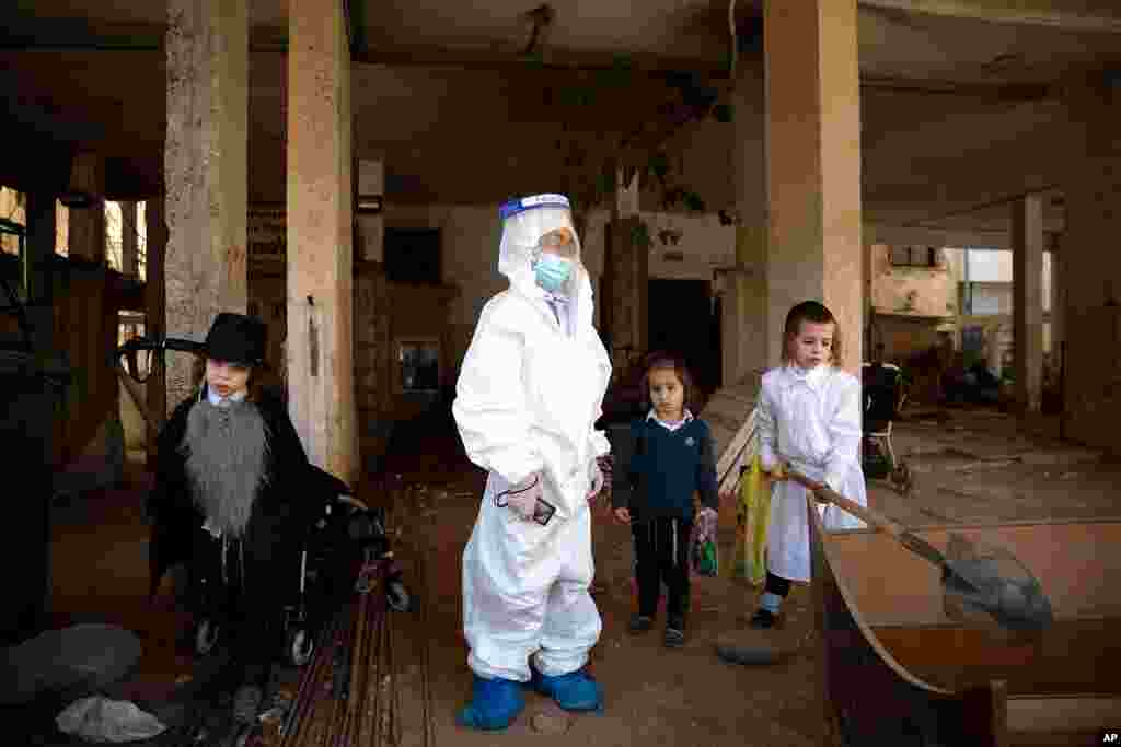 Ultra-Orthodox Jewish children, dressed in gravedigger costumes, celebrate the Jewish holiday of Purim in Bnei Brak, Israel.
