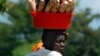 FILE - A Burundian woman carries cassava home from the market in Kinama, a suburb in Burundi's capital, Bujumbura.