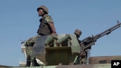FILE - In this image made from video, a Mozambican soldier rides on an armored vehicle at the airport in Mocimboa da Praia, Cabo Delgado province, Mozambique, Aug. 9, 2021. The U.N. Office for the Coordination of Humanitarian Affairs is seeking $413 million to support the region.