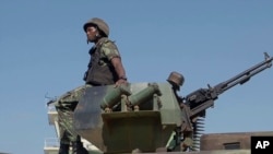 FILE - In this image made from video, a Mozambican soldier rides on an armored vehicle at the airport in Mocimboa da Praia, Cabo Delgado province, Aug. 9, 2021.