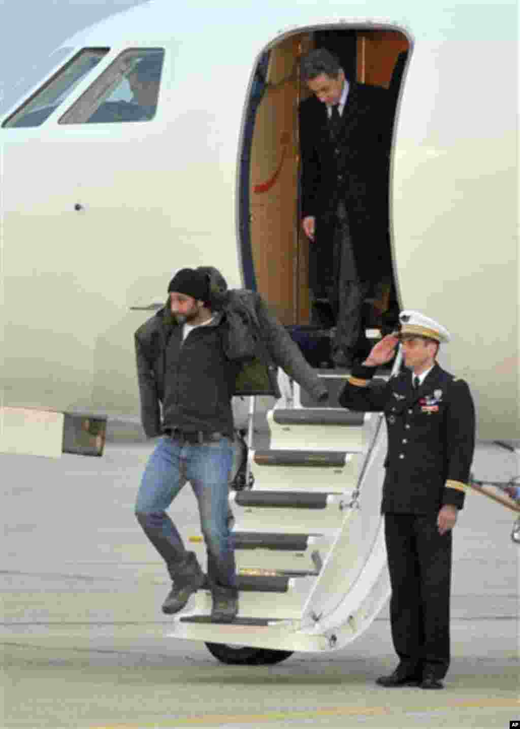 French photographer, William Daniels, bottom, followed by French President, Nicolas Sarkozy, alight from the plane carrying him and French reporter, Edith Bouvier, after they landed at the Villacoublay military airport, outside Paris, Friday, March 2nd, 2