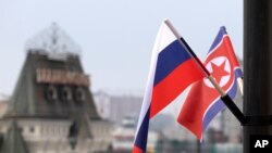 Bendera Rusia dan Korea Utara terlihat di depan stasiun kereta pusat di Vladivostok, Rusia, Rabu, 24 April 2019. (Foto: AP)