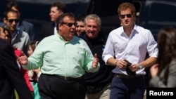 Britain's Prince Harry (R) walks with New Jersey Governor Chris Christie as they view areas of the boardwalk that have been repaired in Seaside Heights, a beach town hit by Hurricane Sandy last year, in New Jersey, May 14, 2013.