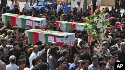 During a funeral ceremony, people carry flag-draped coffins of victims of two bomb blasts in Zahedan, southeast of Tehran, claimed by the Sunni group, Jundallah, 17 Jul 2010