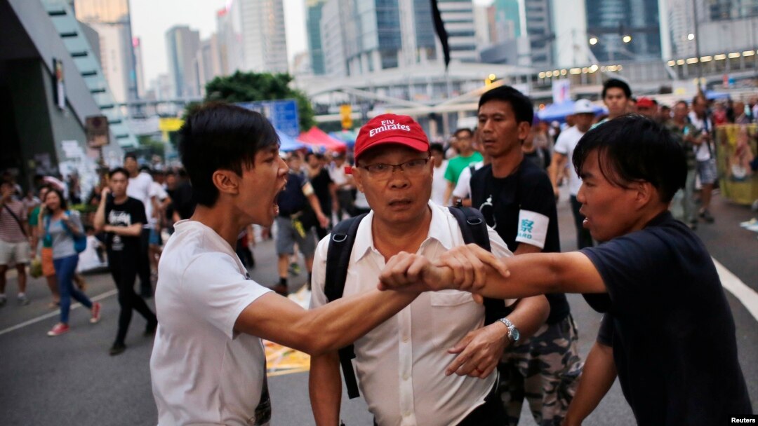 Disputa entre dos manifestantes frente al edificio del gobierno de Hong Kong.