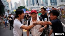 Disputa entre dos manifestantes frente al edificio del gobierno de Hong Kong.