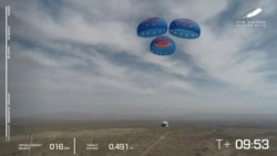 In this image from video made available by Blue Origin, the New Shepard capsule uses parachutes to land during a test in West Texas on Wednesday, April 14, 2021. (Blue Origin via AP)