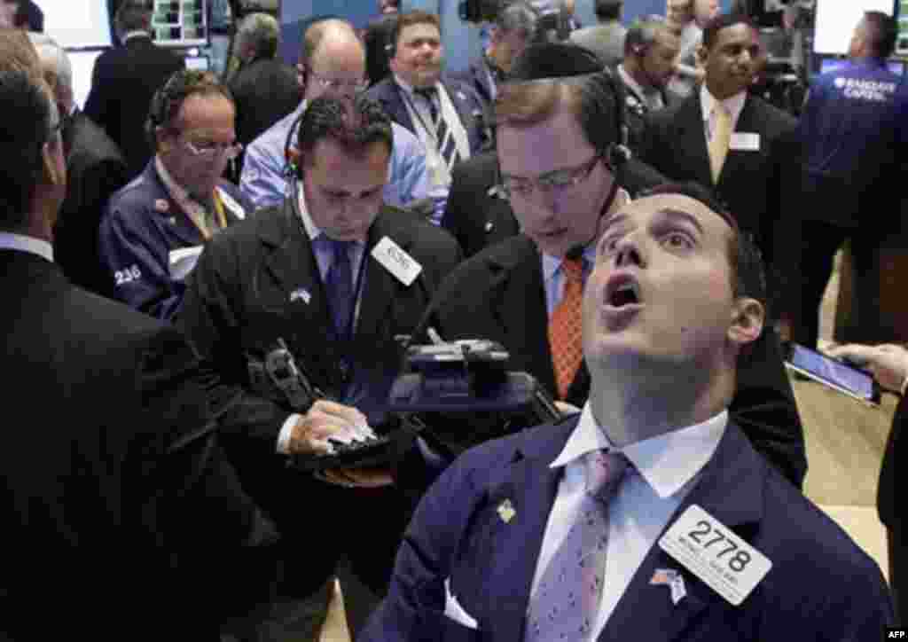 Specialist Michael Gagliano, foreground right, calls out prices at his post on the floor of the New York Stock Exchange Tuesday, Oct. 4, 2011. (AP Photo/Richard Drew)
