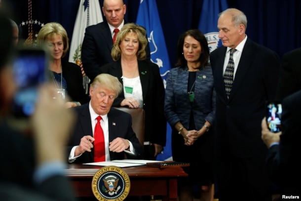 U.S. President Donald Trump signs an executive order at Homeland Security headquarters in Washington, D.C., Jan. 25, 2017.