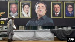 A man walks past an election banner displaying Bilawal Bhutto Zardari (C), chairman of Pakistan Peoples Party (PPP), along a street in Karachi on February 4, 2024, ahead of the upcoming general elections.