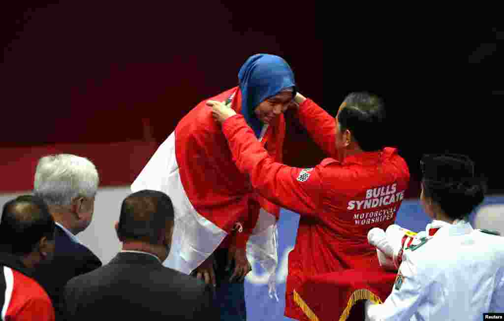 Atlet taekwondo putri Indonesia, Defia Rosmaniar saat menerima medali emas dari Presiden Joko Widodo. (REUTERS/Willy Kurniawan)