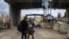 FILE - A Russian soldier inspects a petition from a Syrian man at the entrance of the Russian-leased Syrian military base of Hmeimim in Latakia province in western Syria on Dec. 29, 2024. 