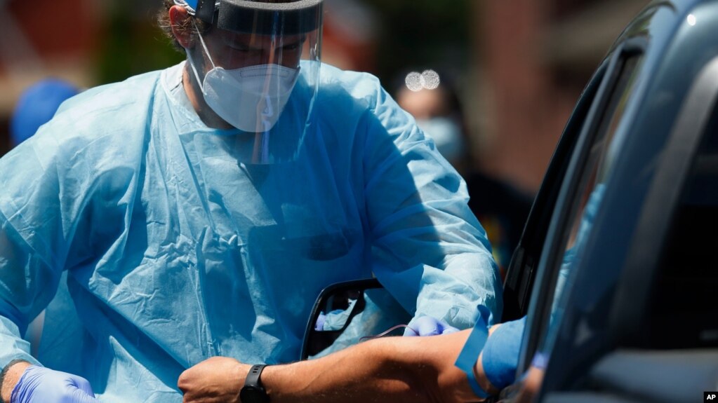 FILE - In this June 12, 2020, file photo, a health worker draws blood for COVID-19 antibody testing in Dearborn, Mich. A genetic analysis of COVID-19 patients published Wednesday, June 17, 2020, in the New England Journal of Medicine suggests a…