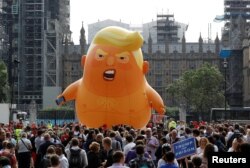 英国抗议者在伦敦议会广场花园放飞了一只6米高的满脸怒容、裹着尿布的“川普宝宝”气球。（2018年7月13日