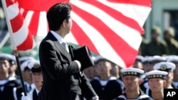 FILE - Japanese Prime Minister Shinzo Abe reviews members of Japan Self-Defense Forces (SDF) during the Self-Defense Forces Day at Asaka Base, north of Tokyo, Sunday, Oct. 27, 2013.