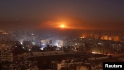 FILE - Smoke and flames rise after air strikes on rebel-controlled besieged area of Aleppo, as seen from a government-held side, in Syria, Dec. 11, 2016.