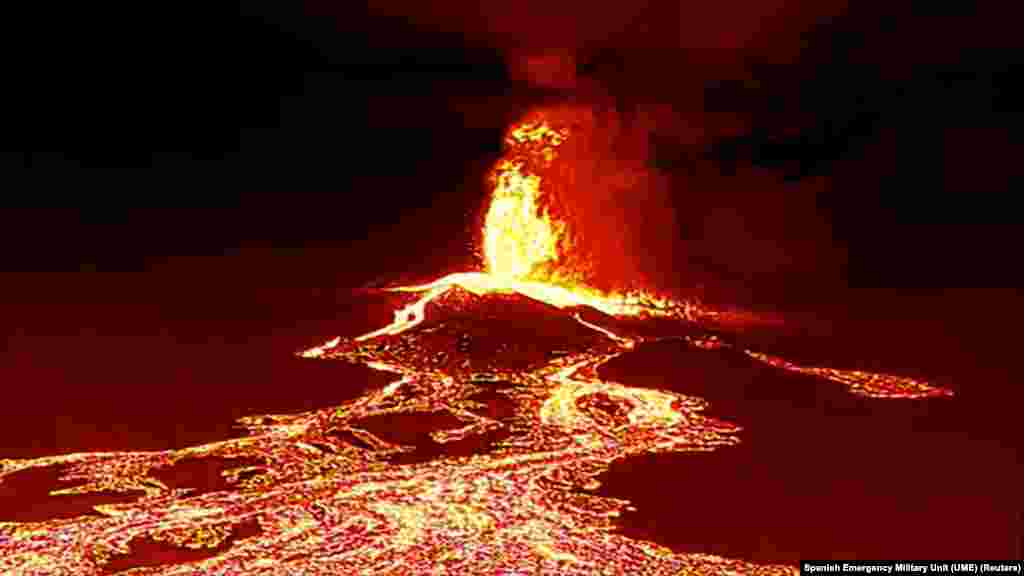 An image from a video taken by a drone at night shows a volcano bursting and lava pouring out, in La Palma, Spain.