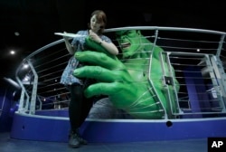 FILE - Madame Tussauds employee Marie Chandler poses for photographers beside a waxwork of The Hulk during the launch of the Marvel Super Heroes 4D exhibit at the Madame Tussauds waxworks in London, June 2, 2010.