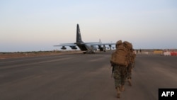 美国国防部公布的照片显示吉布提莱蒙尼尔军营的美国海军与海军陆战队士兵登上一架C-130海军陆战队运输机。（资料照）
