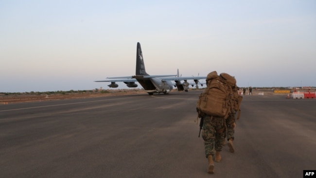 FILE - In this image released by the U.S. Department of Defense, U.S. Marines and sailors prepare to board a KC-130J Marine Super Hercules at Camp Lemonnier, Djibouti.