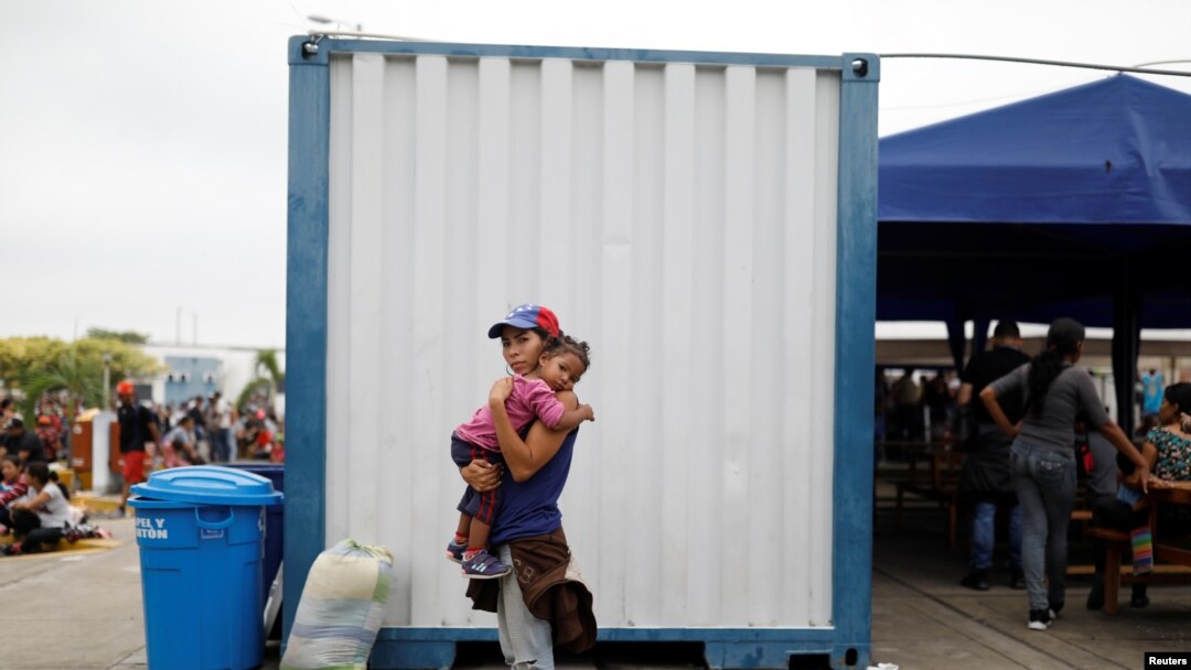 Una joven venezolana espera con su hija en brazos la documentación en la frontera entre Perú y Ecuador para pasar a ese primer país como refugiada.