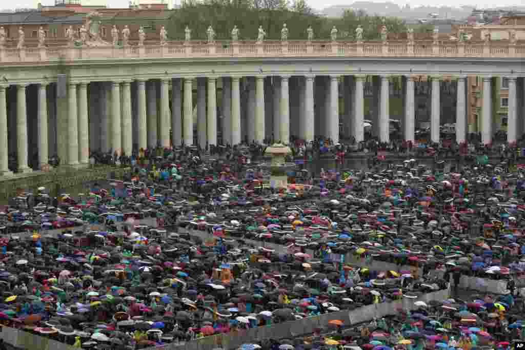 Faithful wait in the rain for Pope Francis&#39; arrival to the Easter Mass in St. Peter&#39;s Square at the Vatican, April 5, 2015.