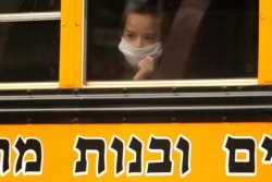 A child wears a mask on a school bus in the Borough Park section of Brooklyn, New York City, New York, Sept. 29, 2020.