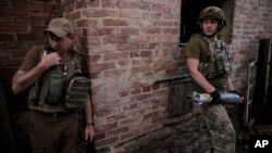 Ukrajinski vojnici, pripadnici 24. mehanizovane brigade, pripremaju granatu 120 mililematorskog minobacača za ispaljivanje ka ruskim položajima, na neotkrivenoj lokaciji u regionu Donjecka, Ukrajina, 4. juna 2024.