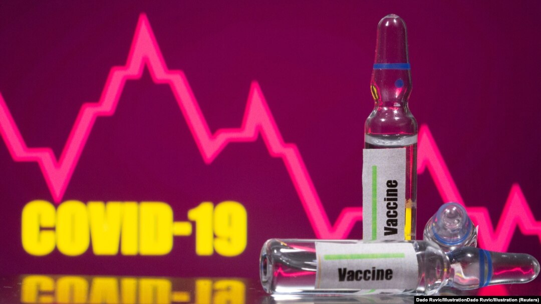 A test tube labelled with the Vaccine is seen in front of Covid-19 and stock graph logo in this illustration taken.