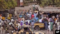 Photo d’archives : des soldats nigérians, à gauche, passent à l'arrière d'un camion armé alors qu’ils patrouillent près d’un marché local mardi 27 janvier 2015, après les récentes violences dans les zones environnantes de Maiduguri, au Nigeria.